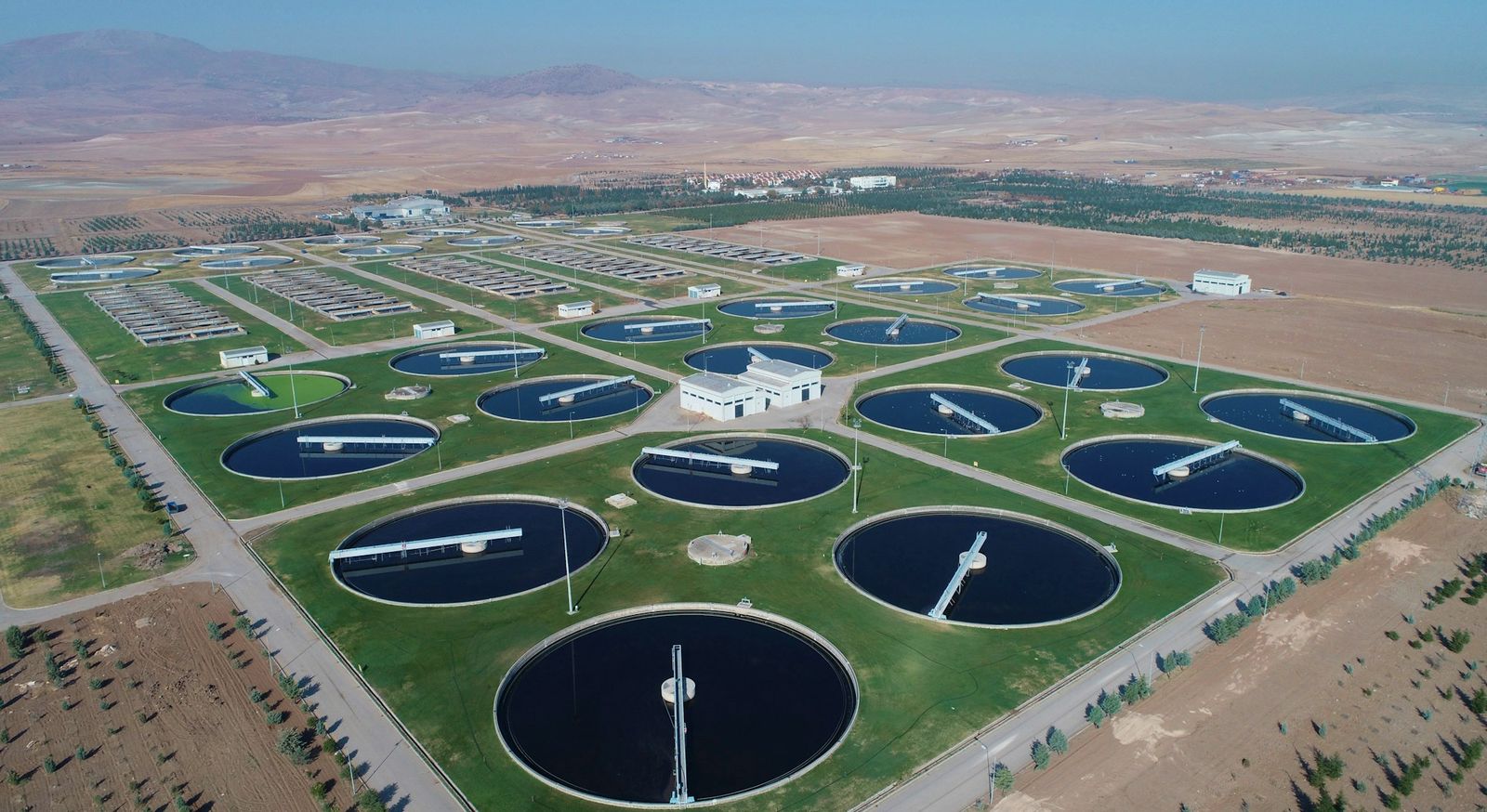 An aerial view of the circular clarifier tanks at a water treatment works